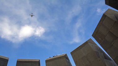 Erivan, Ermenistan - 24 Nisan 2018: quadcopter drone üzerinde mavi gökyüzü taş döşeme üzerinde oturan güvercinler ile Ermeni Soykırımı Anıtı