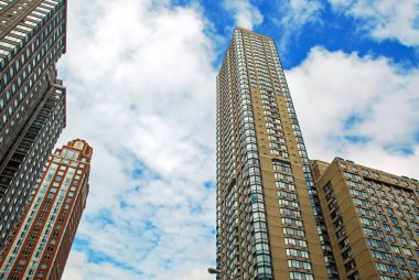 Cityscape Manhattan'daki gökdelen altında mavi bulutlu gökyüzü, New York City, Amerika Birleşik Devletleri ile. Düşük açılı görünüş