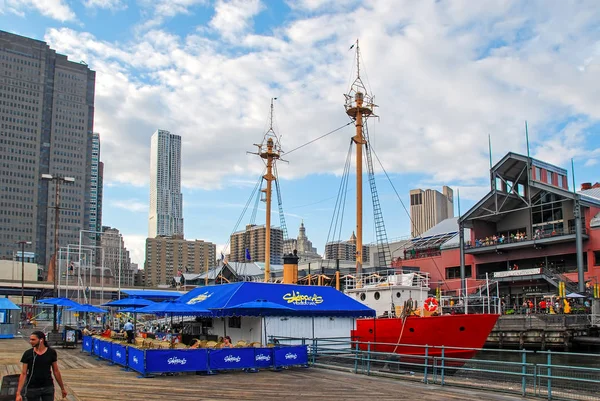 New York City, Amerika Birleşik Devletleri - 11 Ağustos 2012: Yarışçılar Pierside Cafe Manhattan'da ahşap iskele üzerinde mavi şemsiye ile