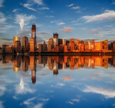 Manhattan şehir manzarası ile New York City, Amerika Birleşik Devletleri içinde günbatımı güneş tarafından aydınlatılmış yansımaları ile nehir üzerinde kentsel gökdelenler