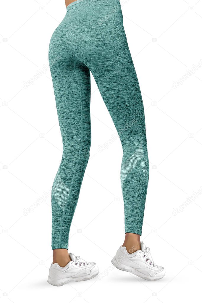 Beautiful slim female legs in turquoise sport leggings and running shoes isolated on white background. Concept of stylish clothes, sports, beauty, fashion and slim legs