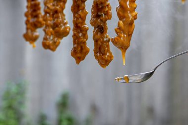 Geleneksel Ermeni tatlı Sujuk 'un (Churchkhela) hazırlanma süreci. Un katılmış üzüm suyundan yapılan kabuklu ceviz (fındık).