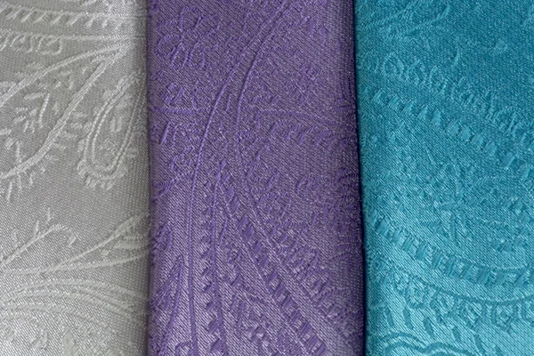 Close-up detailed background with  three mens\' neckties ivory, lavender and aqua with paisley pattern. Bright background with copy space, men fashion and shopping concept