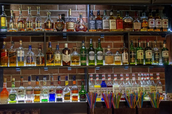 エレバン アルメニア 2019年12月8日 多色のカクテルチューブを前景にしたパブやレストランの棚に並べられたカラフルなアルコールボトル — ストック写真