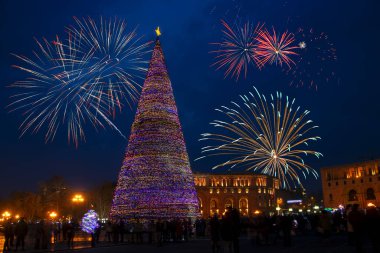 Erivan, Ermenistan 'daki Cumhuriyet Meydanı' nda güzel süslenmiş Noel ağacının üzerinde renkli bir Noel havai fişeği.