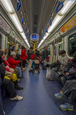 Hong Kong, Çin - 19 Şubat 2014: Metroda seyahat eden insanlar. Metro, Hong Kong 'daki en popüler toplu taşıma biçimidir. Perspektif dikey görünümü