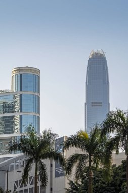 Hong Kong, Çin - 20 Şubat 2014: Hong Kong caddelerinde yoğun trafik ve yeşil ağaçlarla aydınlanan gökdelenlere dikey görüş