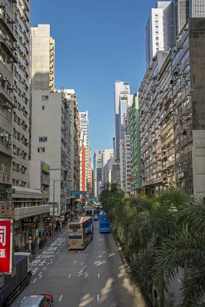 中国香港 2014年2月20日 在繁忙的交通和绿树成荫的香港街道上 由阳光照亮的摩天大楼的垂直景观 — 图库照片
