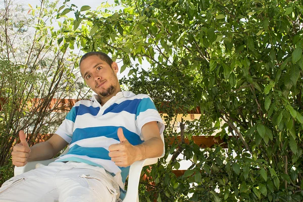 Homme assis sous les arbres — Photo