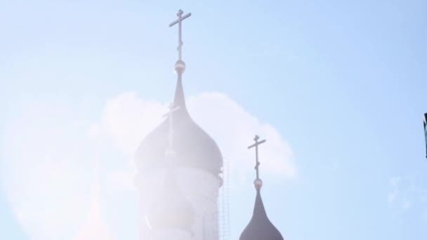 Iglesia contra un cielo azul con nubes a través del resplandor del sol — Vídeo de stock