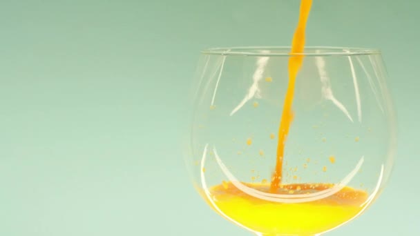 Orange juice is poured into a clear glass cup — Stock Video