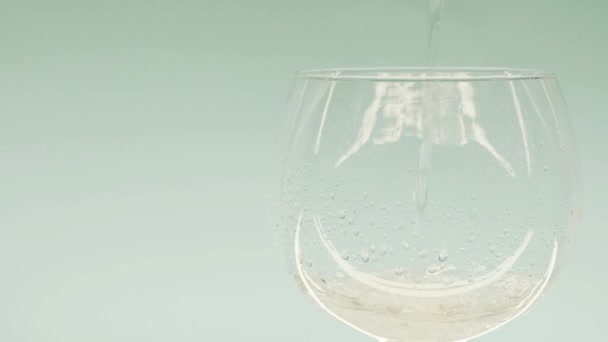 A água é derramada em um copo de vidro transparente — Vídeo de Stock