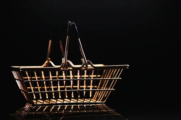 metal basket for a grocery store on a dark background with reflection