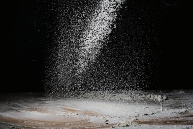 Aydınlatılmış un tanecikleri ve koyu bir arkaplanda bölünmeler