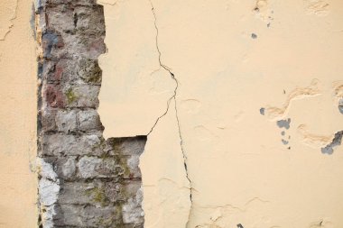 Eski çökmekte sarı tuğla duvar çatlaklar. Doku arka plan.