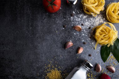 Makarna ve baharatlarla sarımsak, malzemelerin koyu arka plan üzerine. Vejetaryen yiyecekler, sağlık veya pişirme kavramı. Yukarıdan görüntülemek