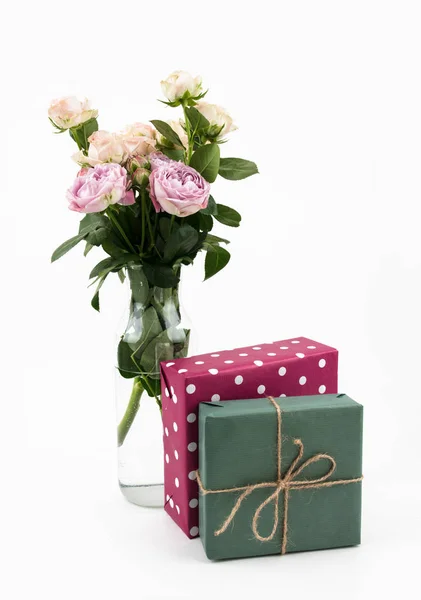 Букет квітів у скляній вазі з подарунком коробки ізольований на білому тлі. Відпустка. Весна — стокове фото
