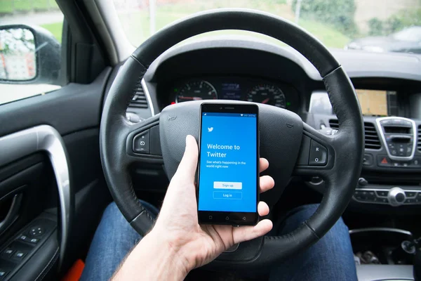 Driver segurando smartphone com aplicativo Twitter — Fotografia de Stock