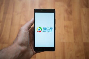 QQ.com logo üstünde smartphone perde