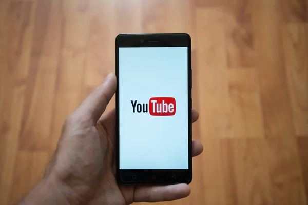 YouTube logo üstünde smartphone perde — Stok fotoğraf