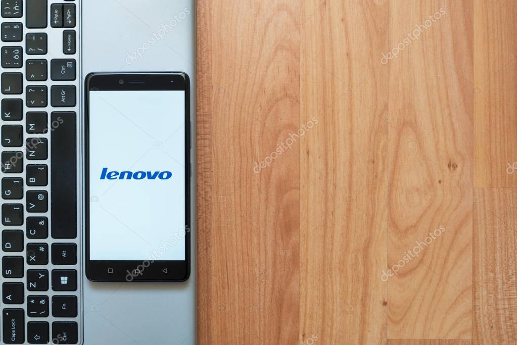Los Angeles, USA, july 18, 2017: Lenovo logo on smartphone screen placed on the laptop on wooden background.