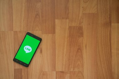 Satır logo üstünde smartphone perde ahşap arka plan üzerinde.