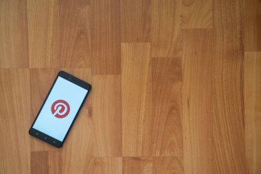Pinterest logo üstünde smartphone perde ahşap arka plan üzerinde.