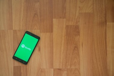 Logo üstünde smartphone perde ahşap arka plan üzerinde spotify.