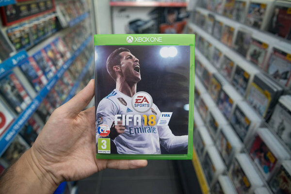 Man holding Fifa 18 videogame on Microsoft XBOX One console in store