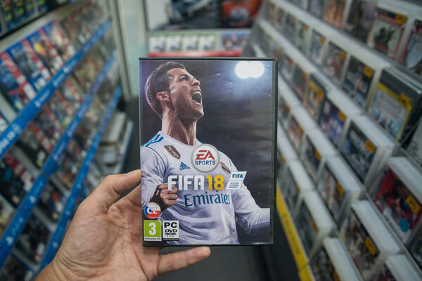 Man holding Fifa 18 videogame on PC in store