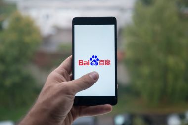 Üstünde belgili tanımlık perde smartphone parmak ile Baidu logolu tutan adam.