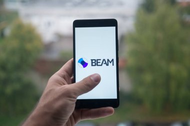 Üstünde belgili tanımlık perde smartphone parmak ile ışını amblemli tutan adam.