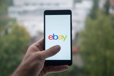 Üstünde belgili tanımlık perde smartphone ile Ebay logosu ile parmak tutan adam.