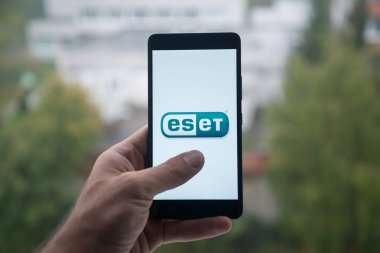 Üstünde belgili tanımlık perde smartphone parmak ile Eset logolu tutan adam.