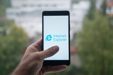 Üstünde belgili tanımlık perde smartphone parmak ile Internet explorer logolu tutan adam.