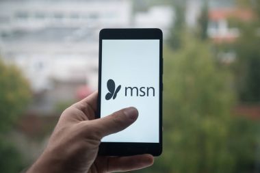 Üstünde belgili tanımlık perde smartphone ile Msn logosu ile parmak tutan adam.