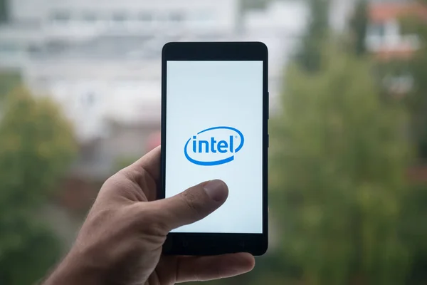 Człowiek posiadający smartfon z logo Intel z palca na ekranie. — Zdjęcie stockowe