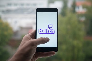 Üstünde belgili tanımlık perde smartphone parmaklı seğirme logolu tutan adam.