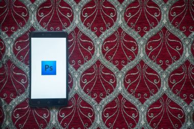 Adobe photoshop logo üstünde smartphone perde