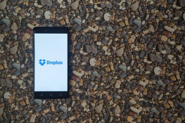 Dropbox logo smartphone cep telefonu ile küçük taş zemin üzerine