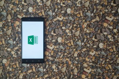 Microsoft office excel logosu smartphone cep telefonu ile küçük taş zemin üzerine