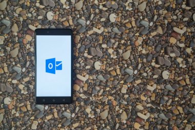 Microsoft office outlook logosu smartphone cep telefonu ile küçük taş zemin üzerine