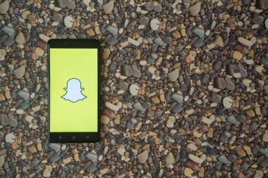 Snapchat logo smartphone cep telefonu ile küçük taş zemin üzerine