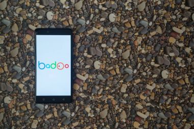 Badoo logo smartphone cep telefonu ile küçük taş zemin üzerine