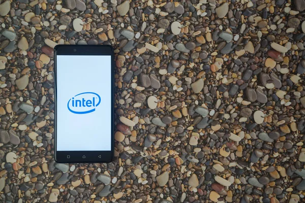 Logotipo de Intel en el teléfono inteligente en el fondo de piedras pequeñas — Foto de Stock