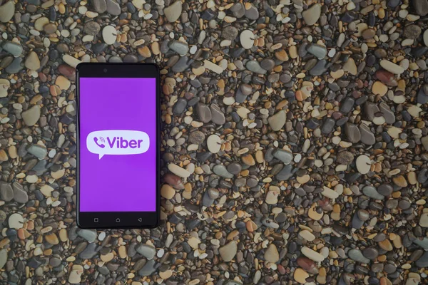 Logotipo Viber en el teléfono inteligente en el fondo de piedras pequeñas — Foto de Stock