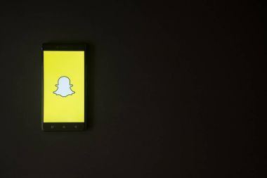 Snapchat logo üstünde smartphone perde siyah arka plan üzerine