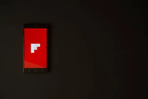 Flipboard λογότυπο στην οθόνη του smartphone σε μαύρο φόντο — Φωτογραφία Αρχείου