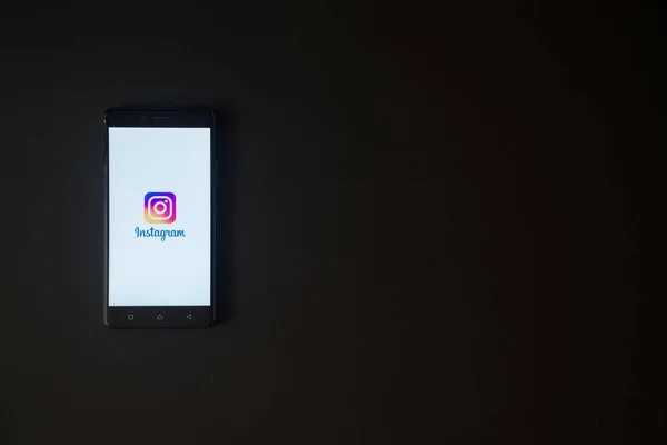 Instagram logo üstünde smartphone perde siyah arka plan üzerine — Stok fotoğraf