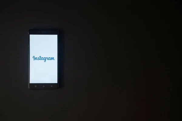 Instagram logo üstünde smartphone perde siyah arka plan üzerine — Stok fotoğraf